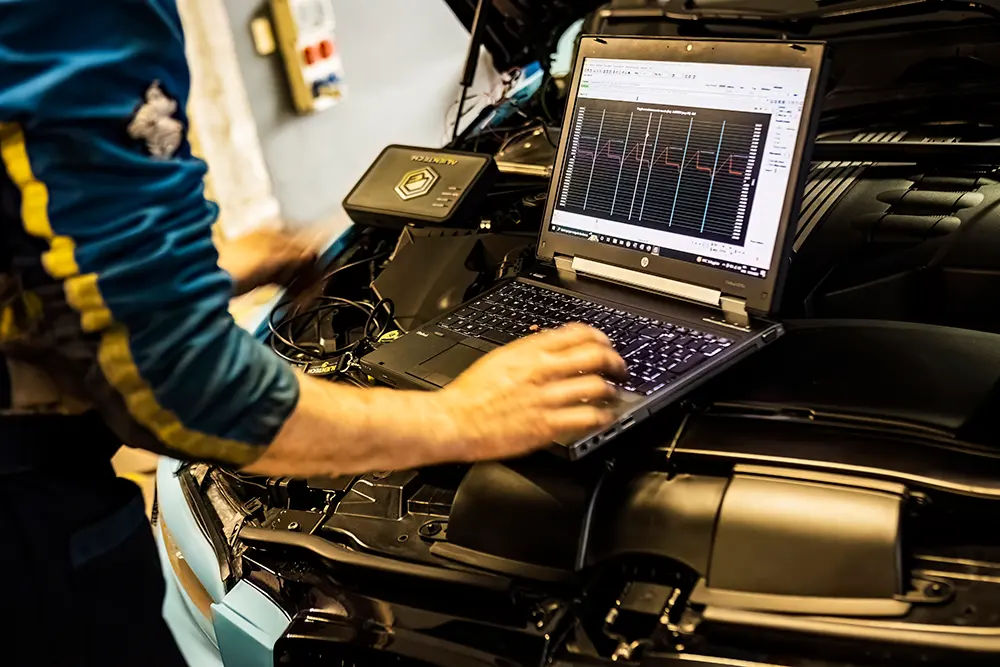 Monteur voert chiptuning uit op een auto in de werkplaats